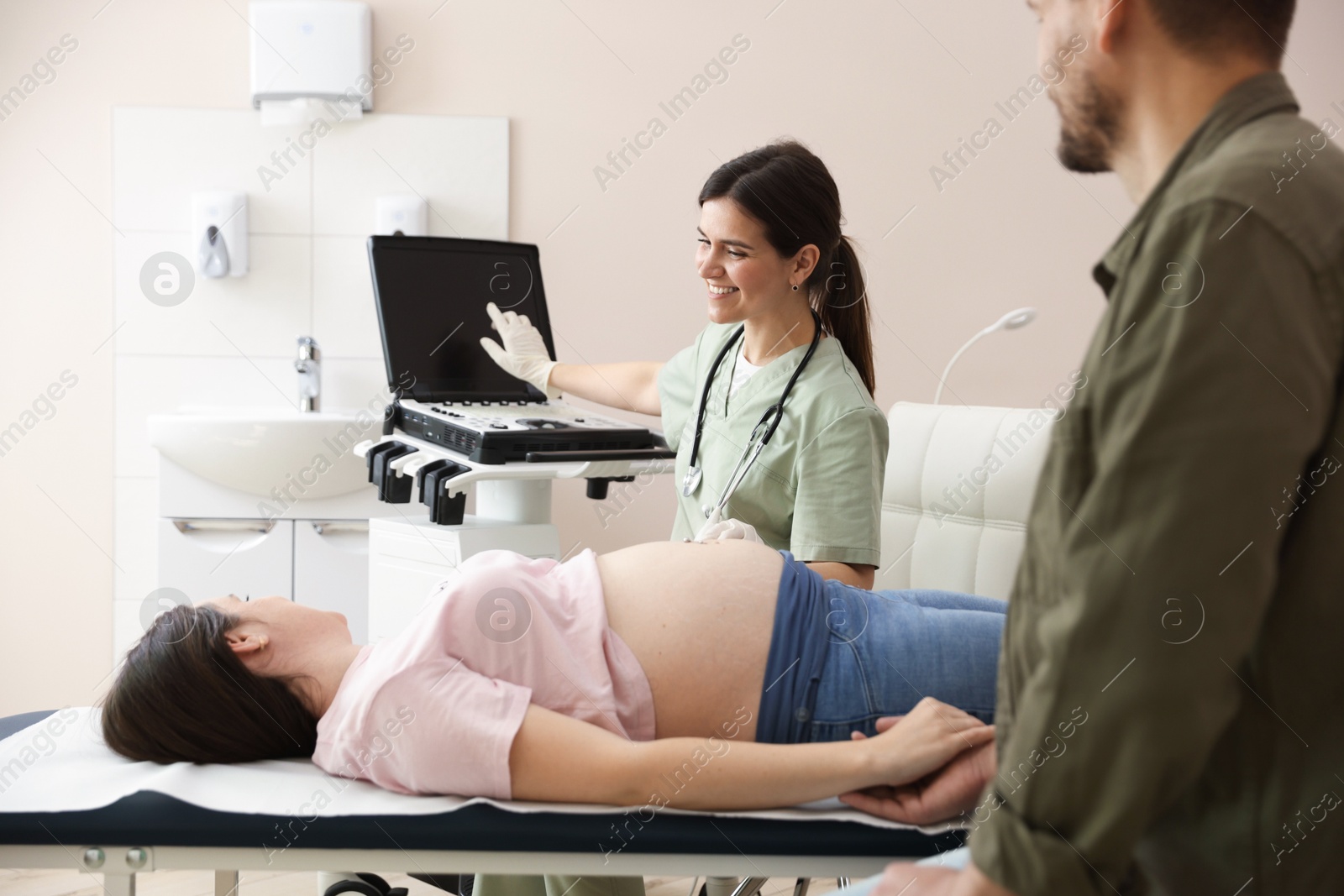 Photo of Woman and her husband attending prenatal ultrasound examination in clinic