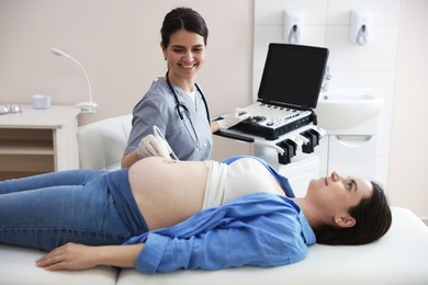 Photo of Sonographer conducting woman's prenatal ultrasound examination in clinic