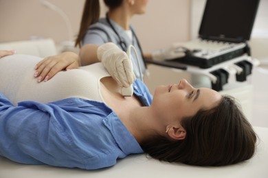 Photo of Sonographer conducting ultrasound examination of woman's thyroid gland in clinic, closeup