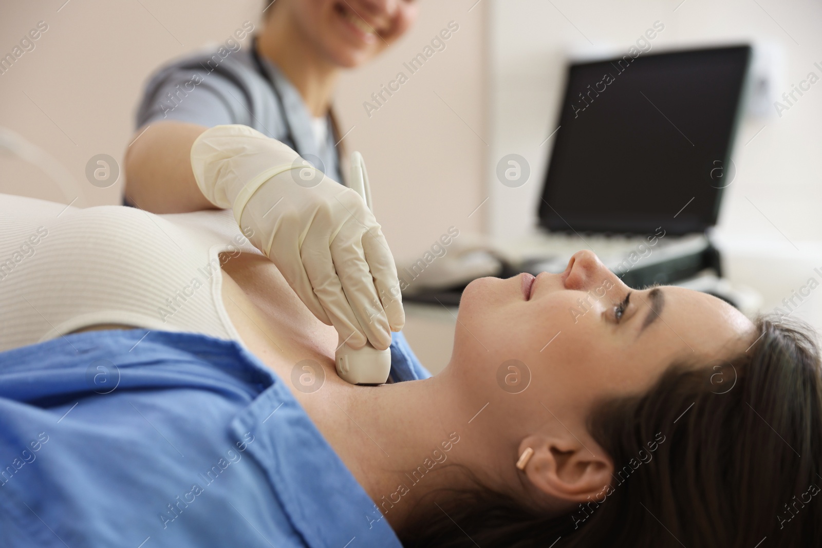 Sonographer conducting ultrasound examination of woman's thyroid gland in clinic, closeup Photo of Sonographer conducting ultrasound examination of woman's thyroid gland in clinic, closeup