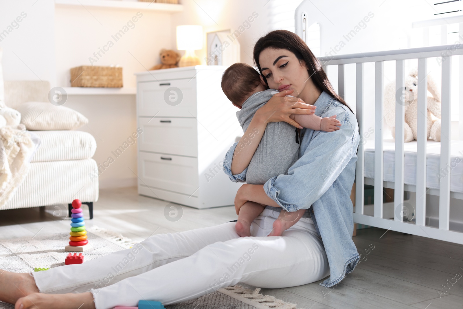 Photo of Woman suffering from postpartum depression with her little baby at home. Space for text