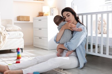 Photo of Woman suffering from postpartum depression with her little baby at home. Space for text