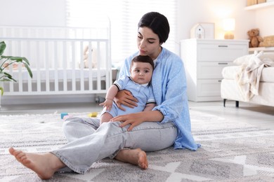 Photo of Woman suffering from postpartum depression with her little baby at home