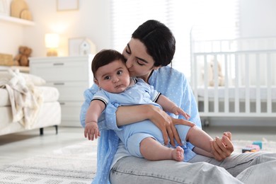 Photo of Mother kissing her cute baby at home