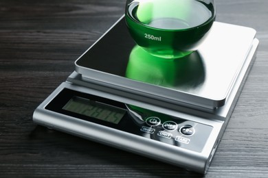 Photo of Laboratory scale with flask of sample on wooden table, closeup