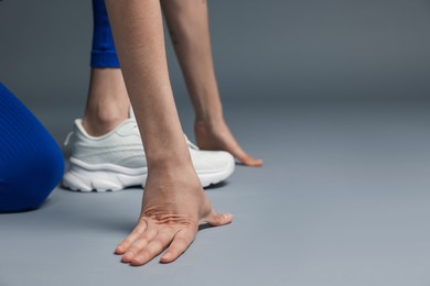 Photo of Runner in starting position on gray background, closeup. Space for text