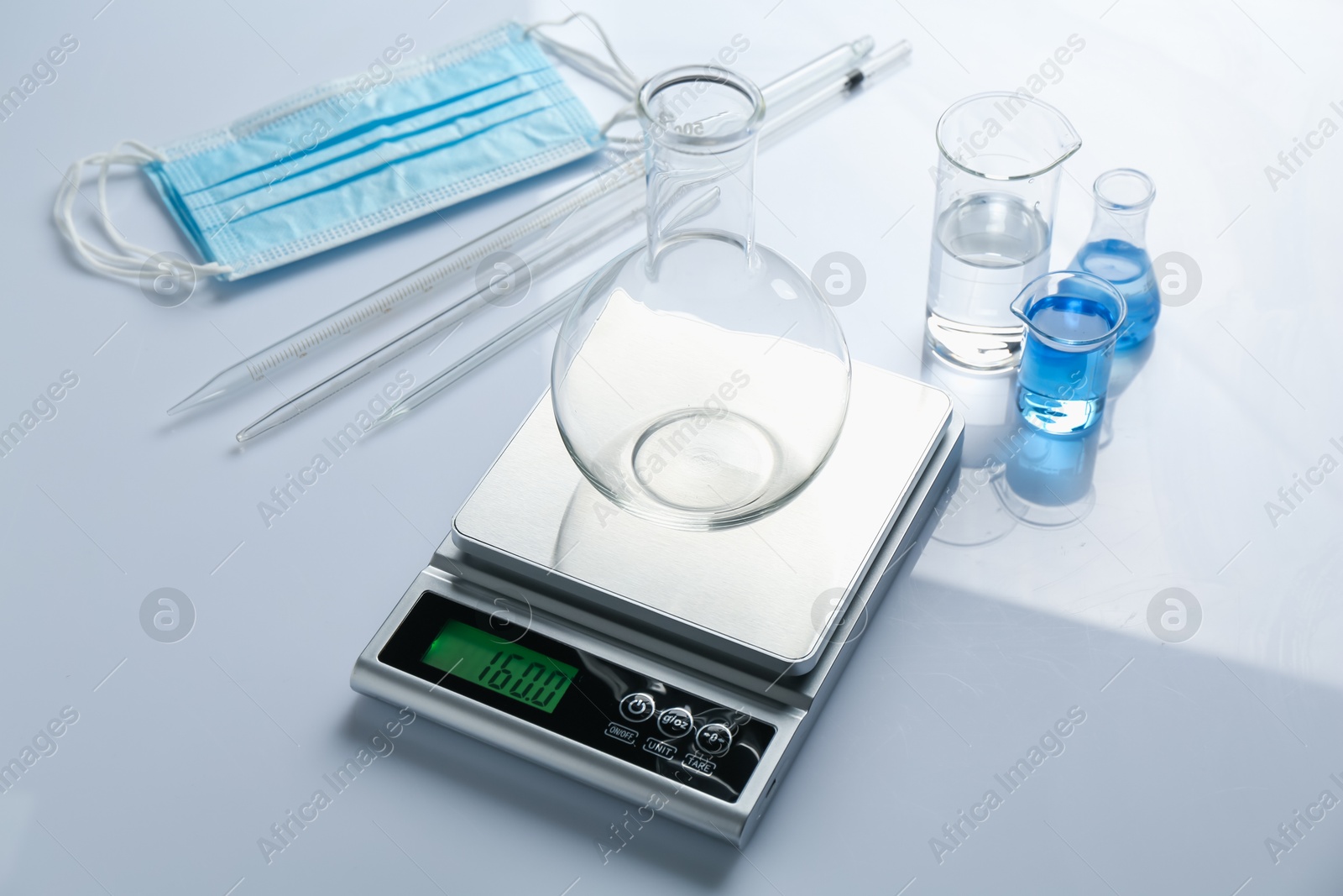 Scale with flask and other laboratory equipment on white background Photo of Scale with flask and other laboratory equipment on white background