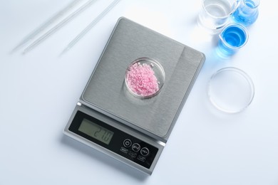 Photo of Scale with Petri dish of sample and other laboratory equipment on white background, flat lay