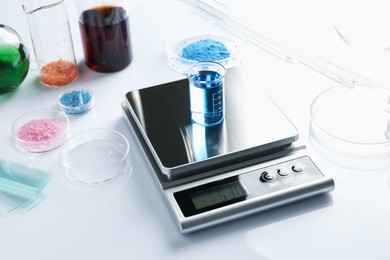 Photo of Scale with beaker of sample and other laboratory equipment on white background