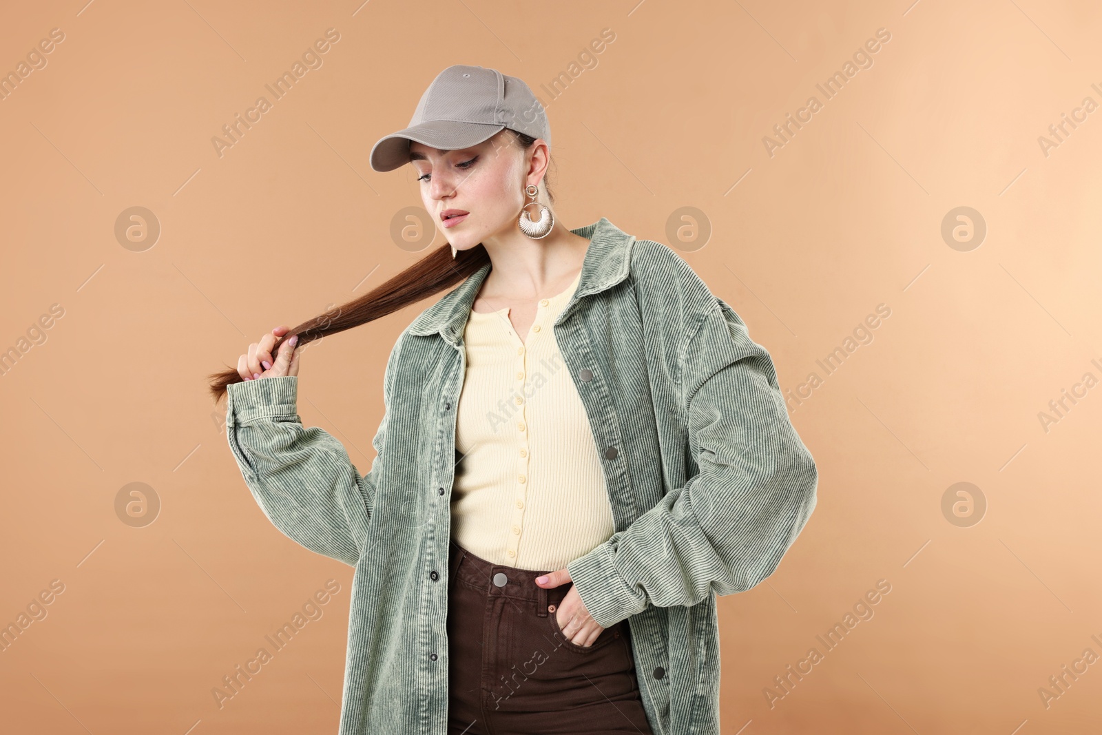 Photo of Beautiful woman in stylish baseball hat on beige background