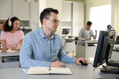 Photo of People working at desks in library, selective focus