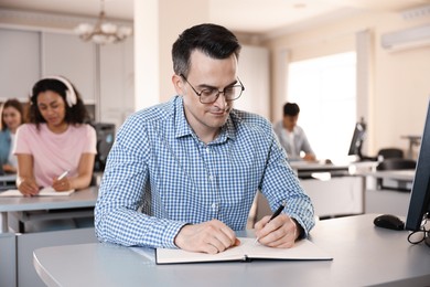 Photo of People studying at desks in public library, selective focus