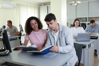 Photo of People studying together at desk in library, selective focus