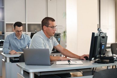 Photo of People studying at desks in library, selective focus