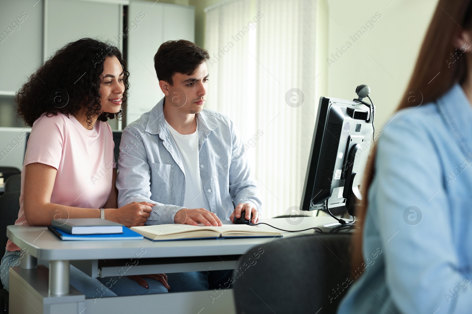 Photo of People studying together at desk in public library