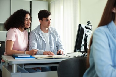 Photo of People studying together at desk in public library