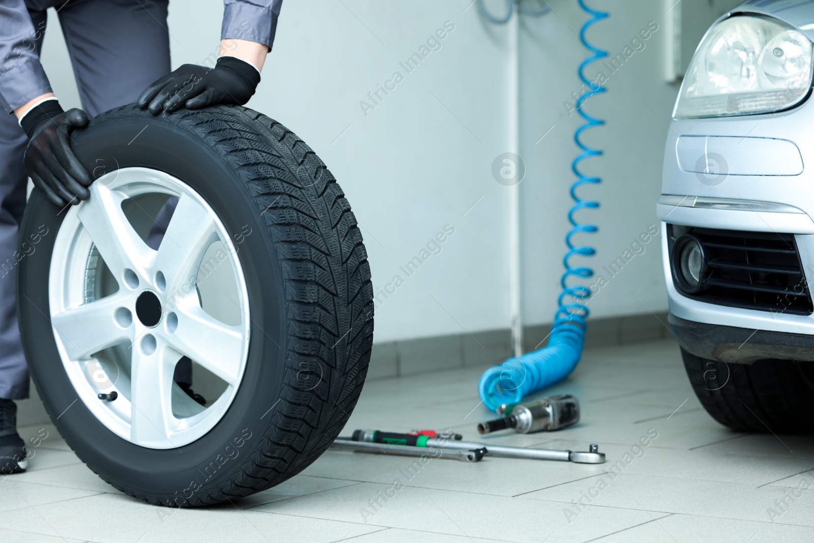 Mechanic changing tire at car service, closeup Photo of Mechanic changing tire at car service, closeup