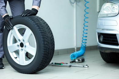 Photo of Mechanic changing tire at car service, closeup