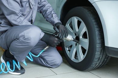 Photo of Mechanic changing tire at car service, closeup