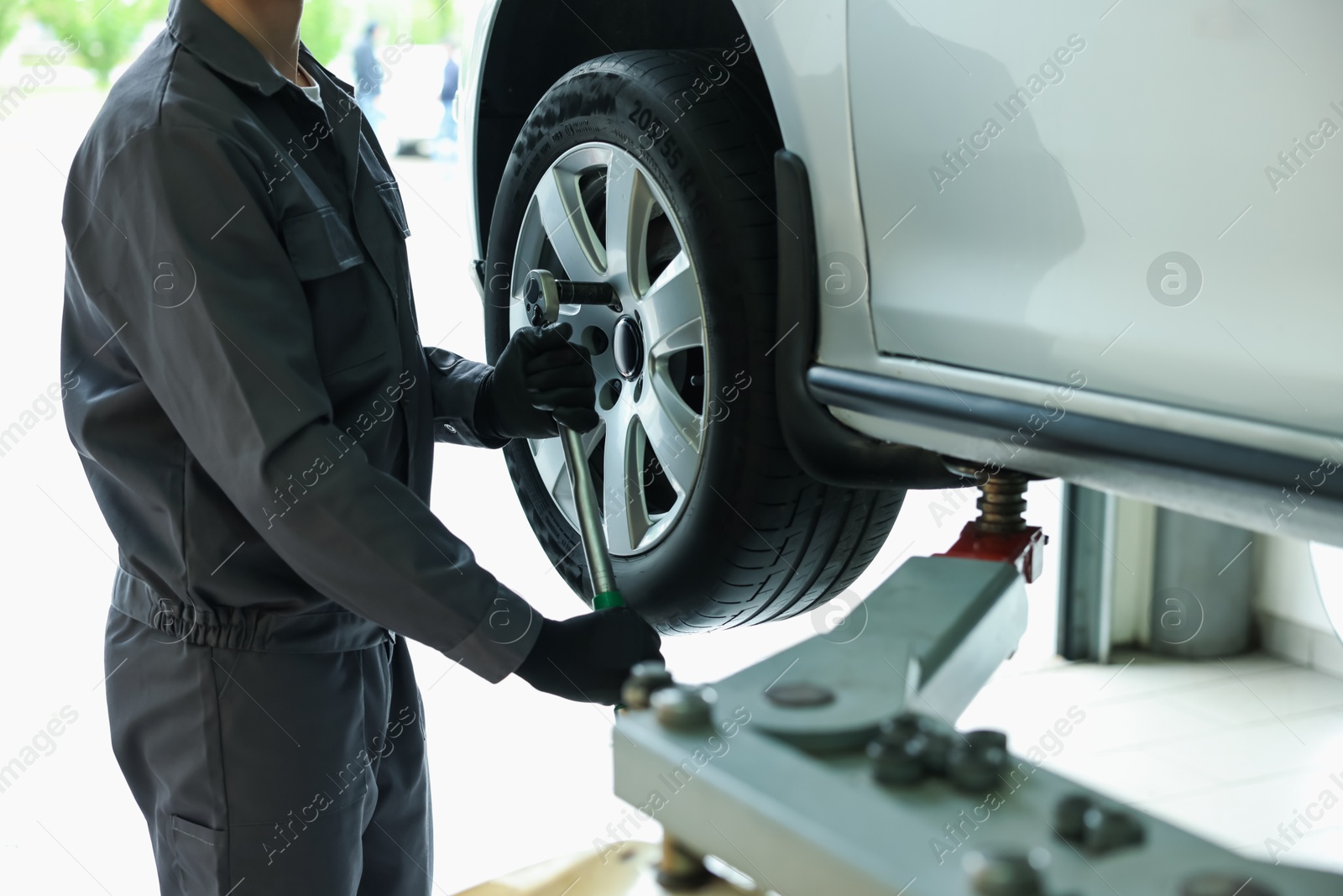 Mechanic changing tire at car service, closeup Photo of Mechanic changing tire at car service, closeup