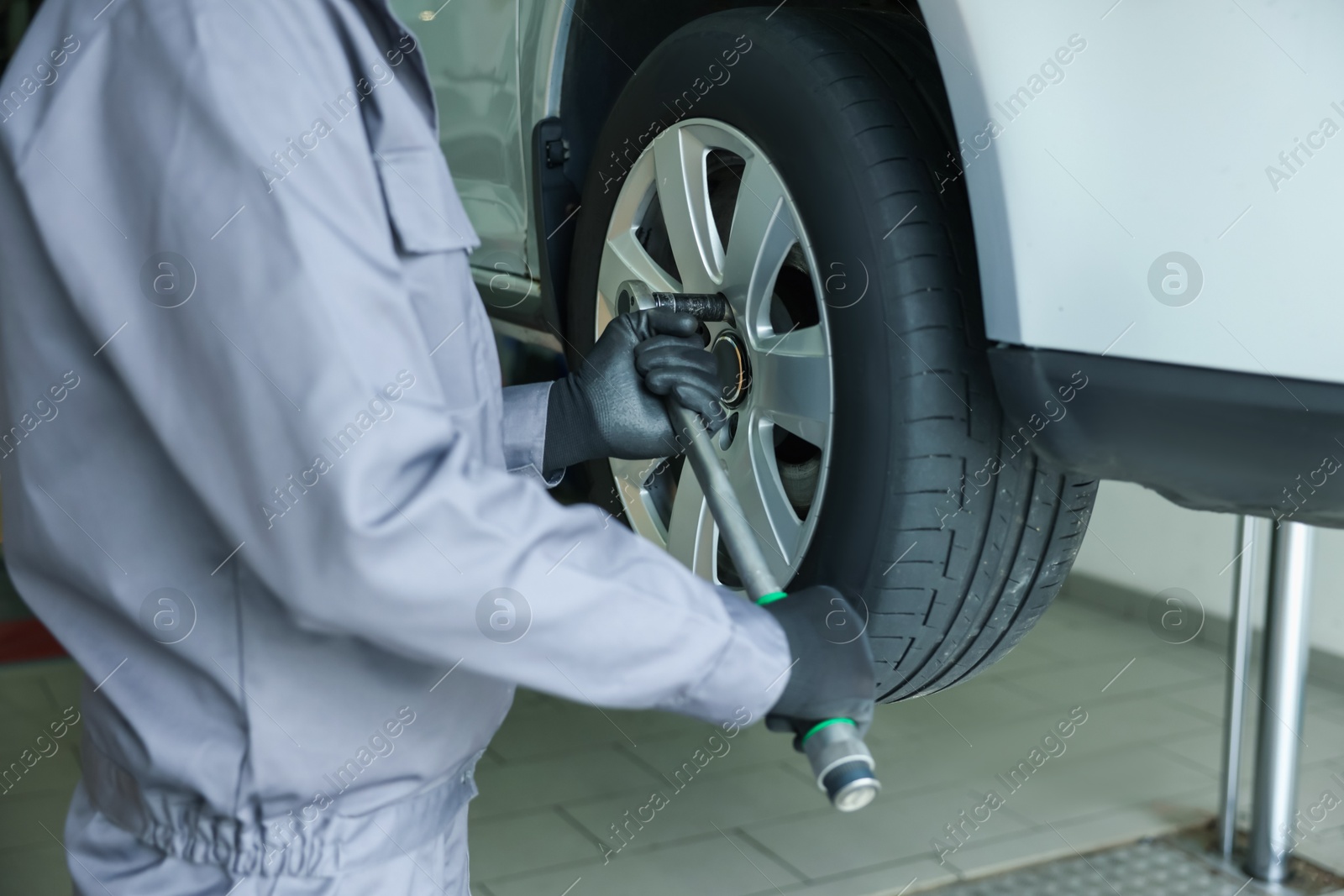 Mechanic changing tire at car service, closeup Photo of Mechanic changing tire at car service, closeup