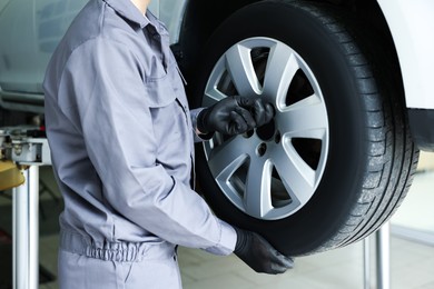 Photo of Mechanic changing tire at car service, closeup