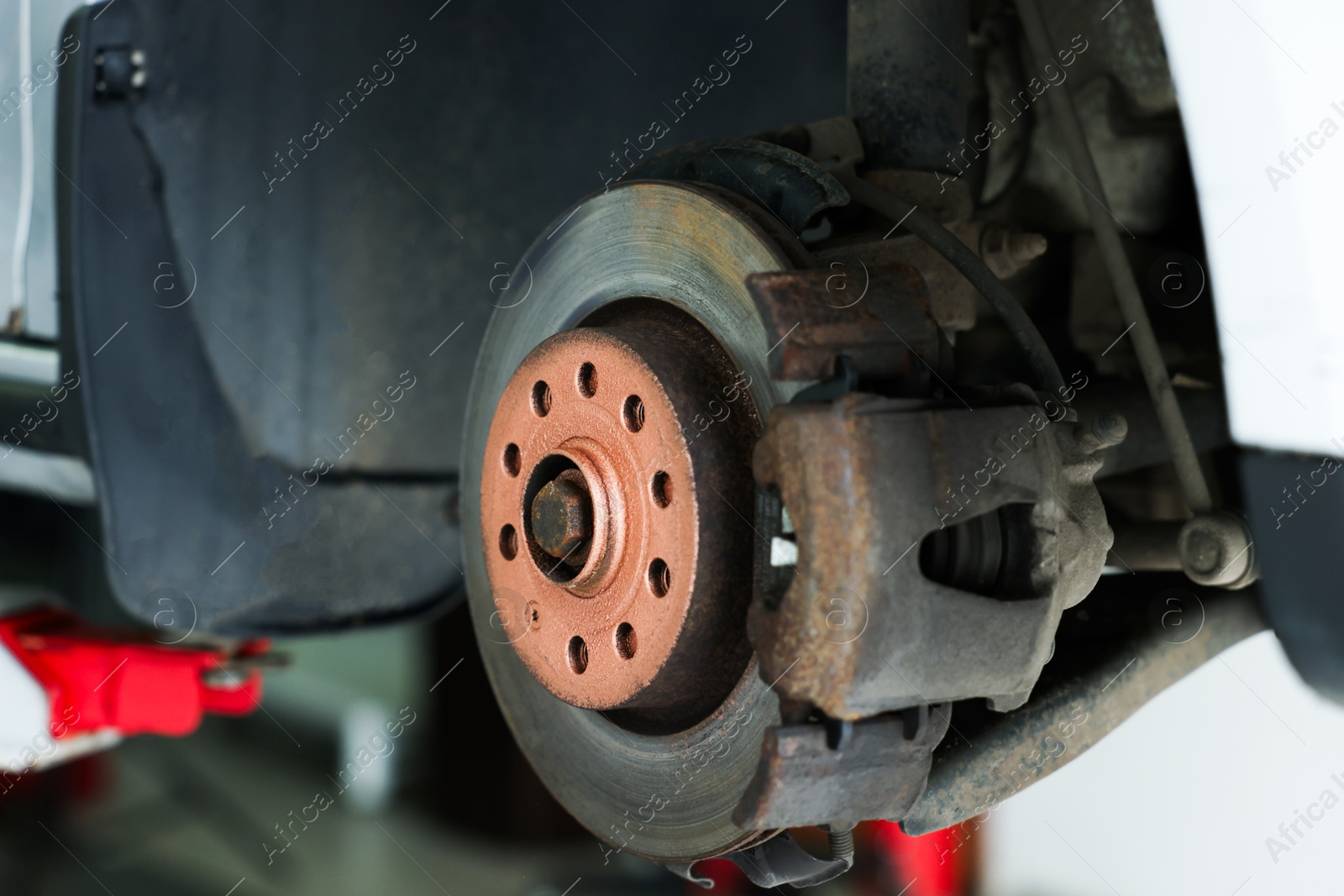 Lifted automobile during tire change at car service, closeup Photo of Lifted automobile during tire change at car service, closeup