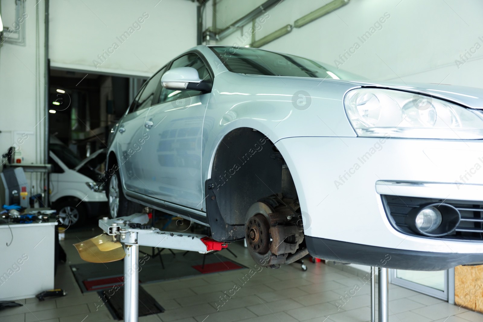 Lifted automobile during tire change at car service Photo of Lifted automobile during tire change at car service