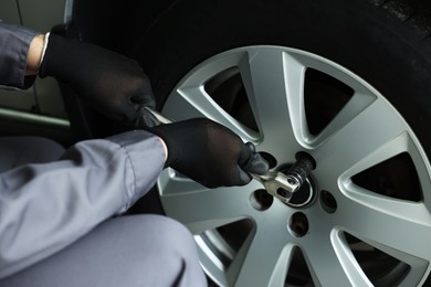 Photo of Mechanic changing tire at car service, closeup