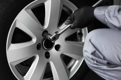 Photo of Mechanic changing tire at car service, closeup