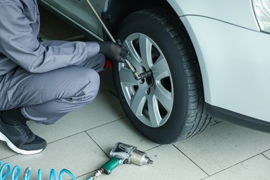 Photo of Mechanic changing tire at car service, closeup