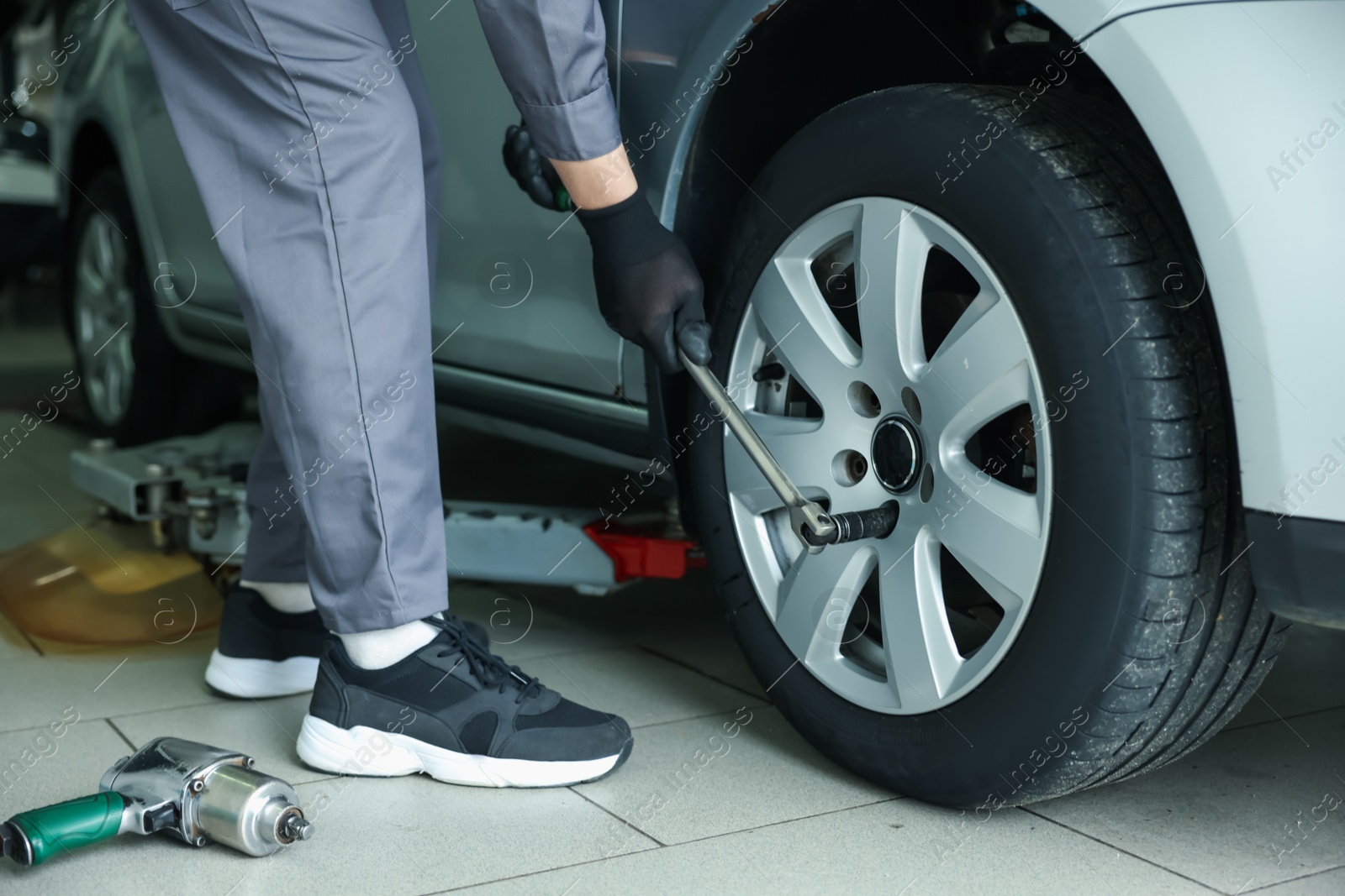 Mechanic changing tire at car service, closeup Photo of Mechanic changing tire at car service, closeup
