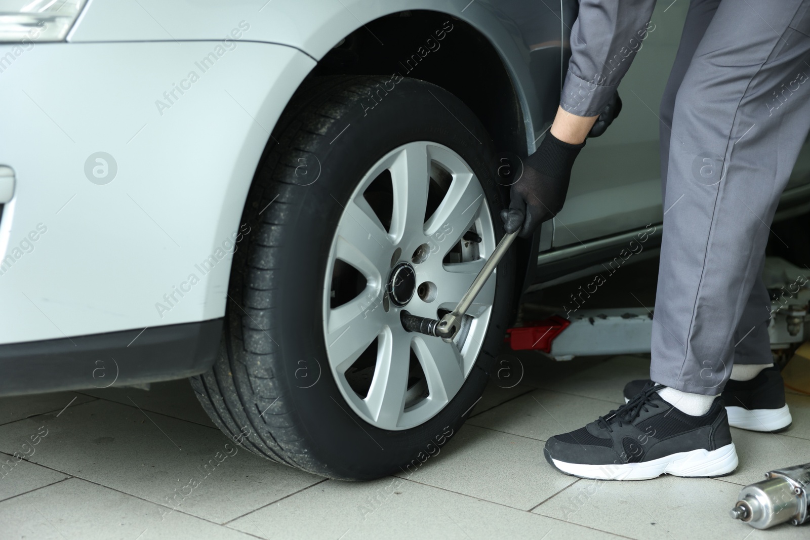Mechanic changing tire at car service, closeup Photo of Mechanic changing tire at car service, closeup