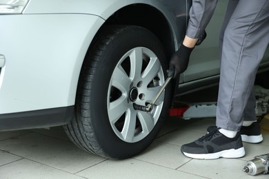 Photo of Mechanic changing tire at car service, closeup