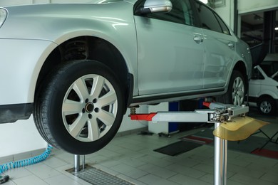 Photo of Lifted automobile during tire change at car service
