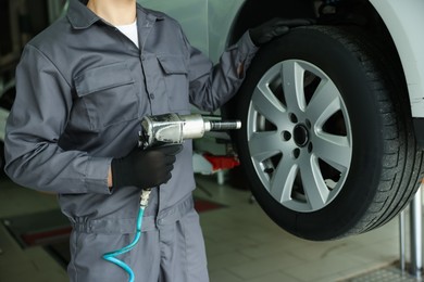 Photo of Mechanic changing tire at car service, closeup