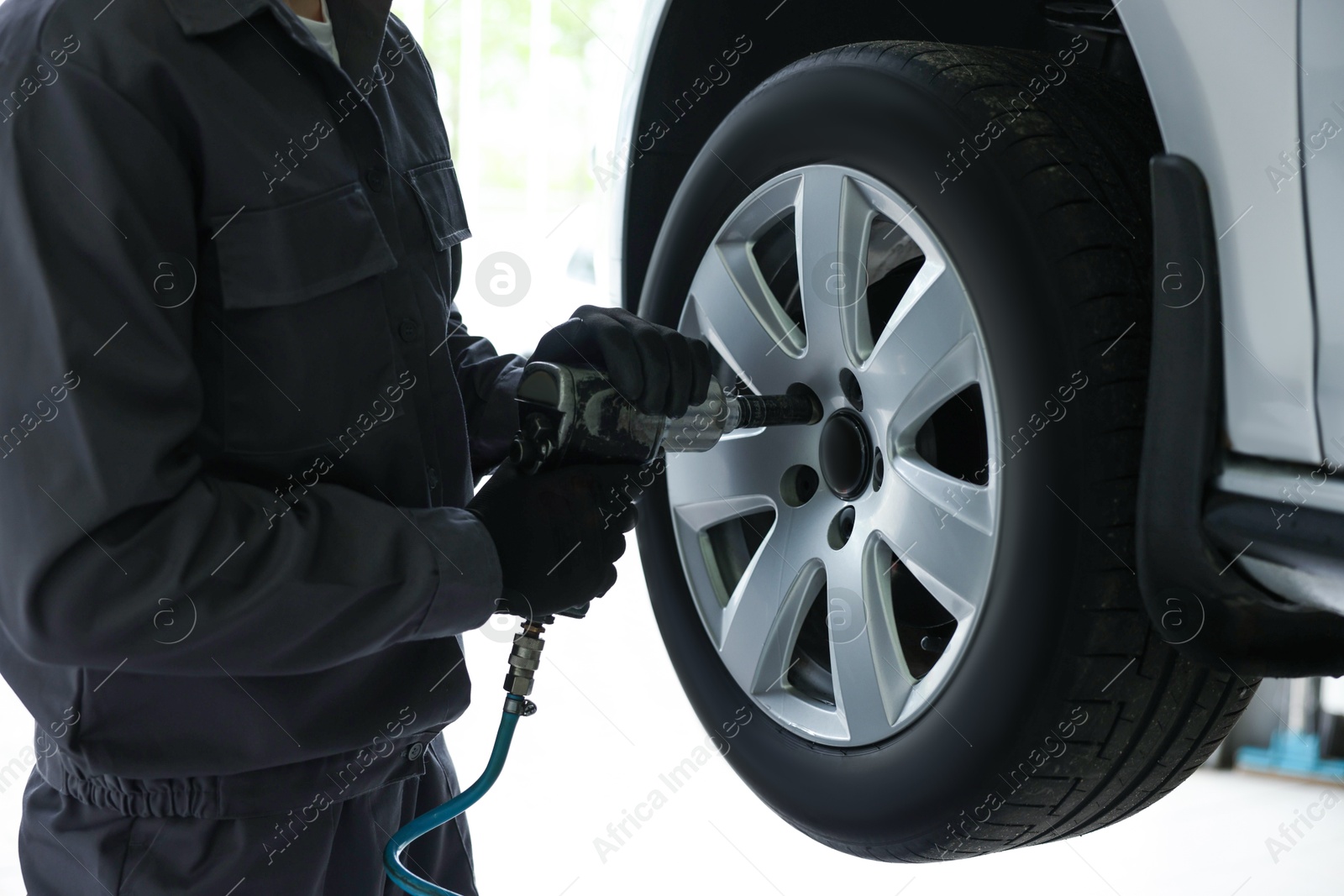 Mechanic changing tire at car service, closeup Photo of Mechanic changing tire at car service, closeup