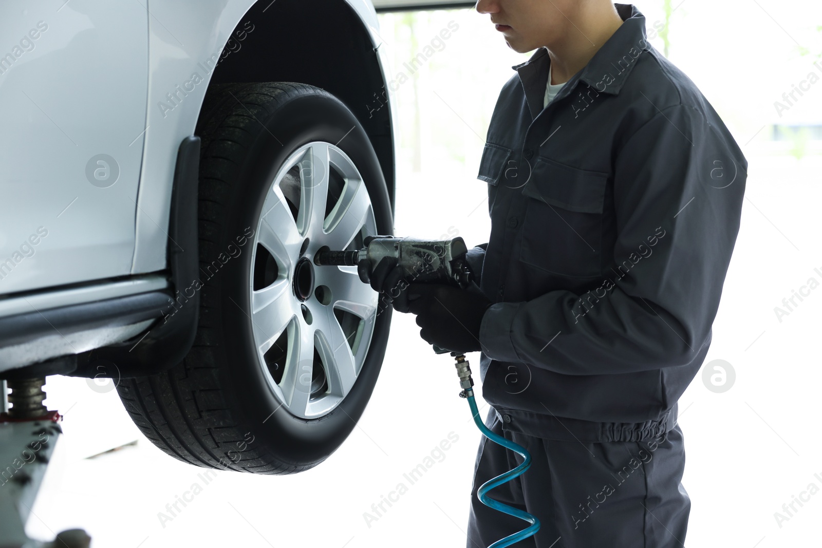 Mechanic changing tire at car service, closeup Photo of Mechanic changing tire at car service, closeup