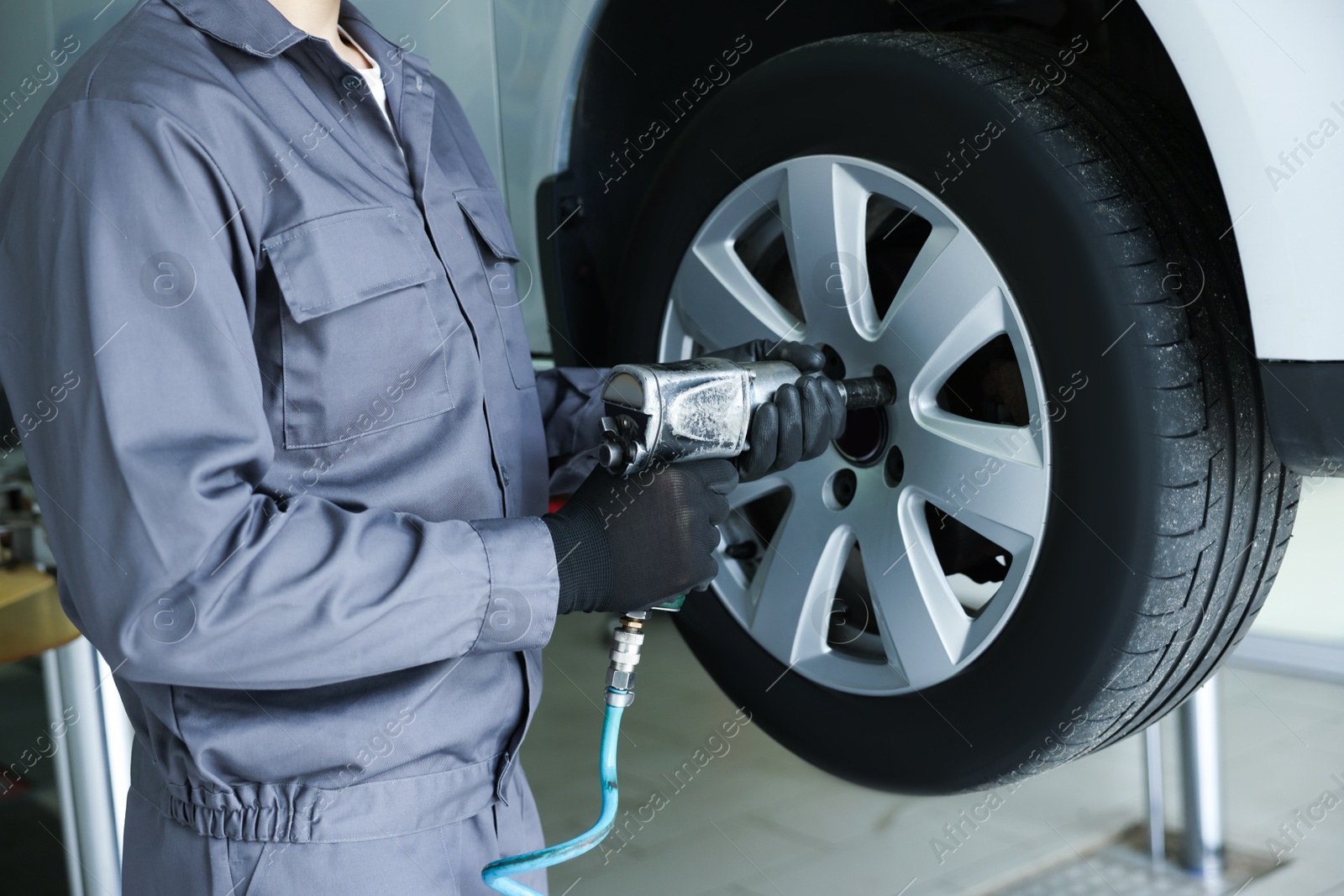 Mechanic changing tire at car service, closeup Photo of Mechanic changing tire at car service, closeup