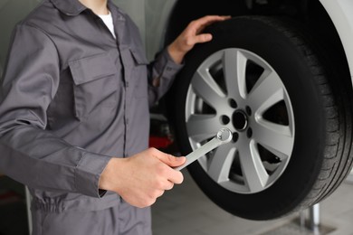 Photo of Mechanic changing tire at car service, closeup
