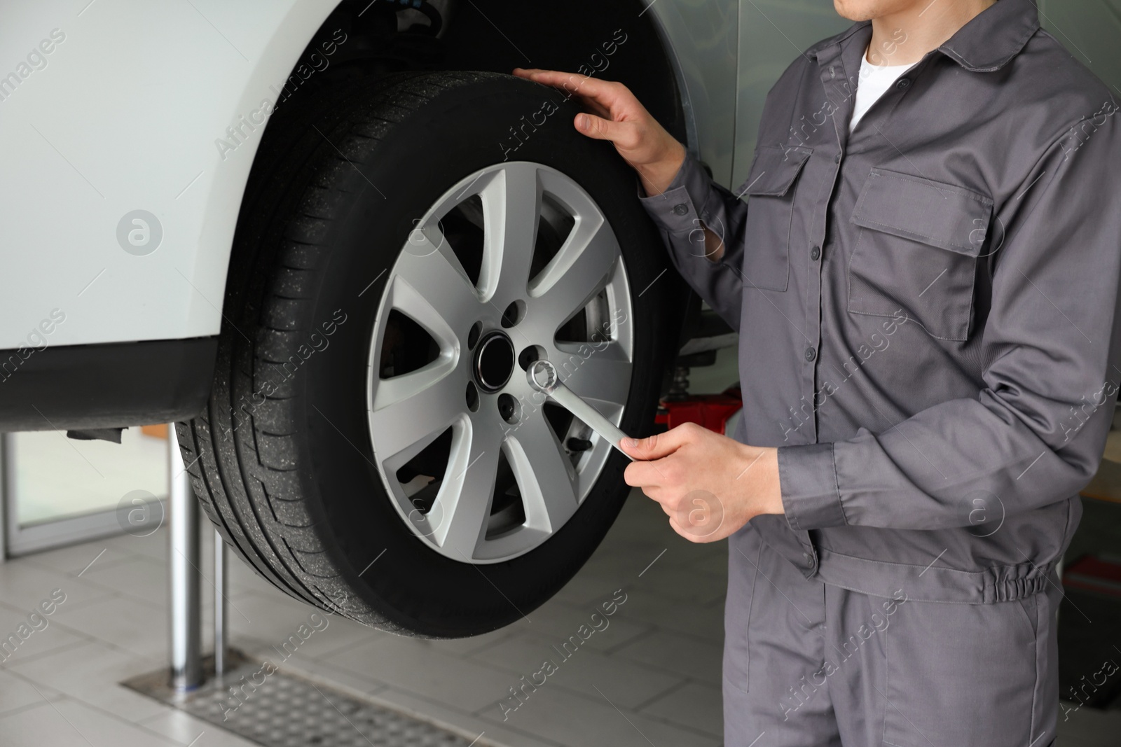 Mechanic changing tire at car service, closeup Photo of Mechanic changing tire at car service, closeup
