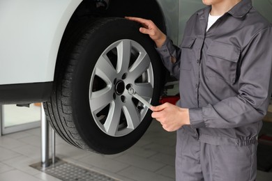 Photo of Mechanic changing tire at car service, closeup