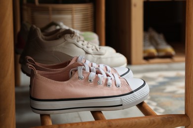 Photo of Different footwear on bench indoors. Shoe storage