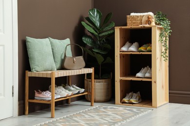 Photo of Different footwear on shelves in entryway. Shoe storage