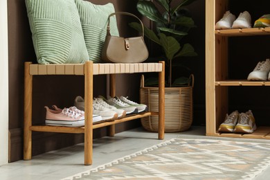 Photo of Different footwear on shelves in entryway. Shoe storage