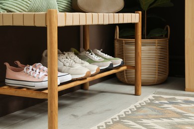 Photo of Different footwear on bench indoors. Shoe storage