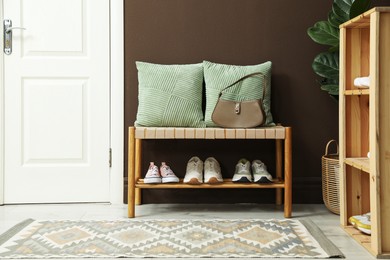 Photo of Different footwear on bench indoors. Shoe storage