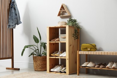Photo of Different footwear on shelves in entryway. Shoe storage