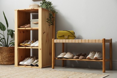 Photo of Different footwear on shelves in entryway. Shoe storage