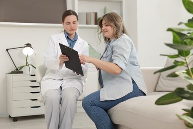 Photo of Weight loss. Nutritionist consulting overweight woman in clinic